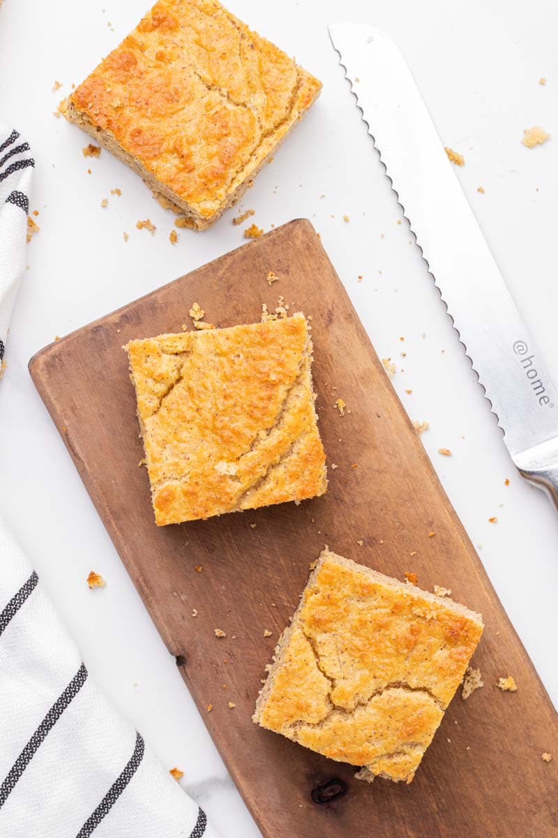 3 cuadrados de pan de maíz bajo en carbohidratos en una tabla de cortar de madera