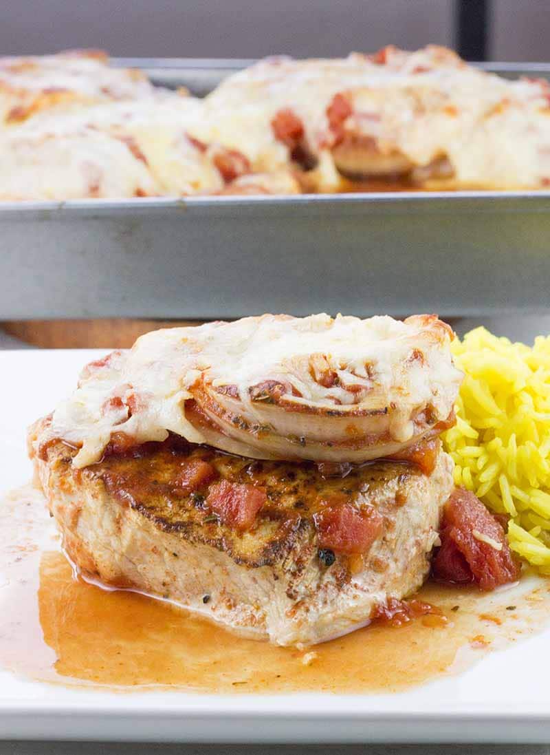 Chuletas de cerdo deshuesadas al horno en salsa de tomate con arroz al lado