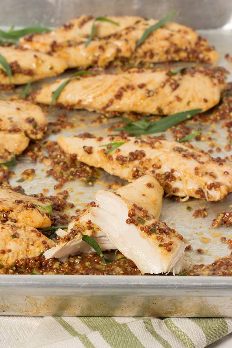 Tiras de pollo al horno con mostaza en una fuente para horno, listas para servir